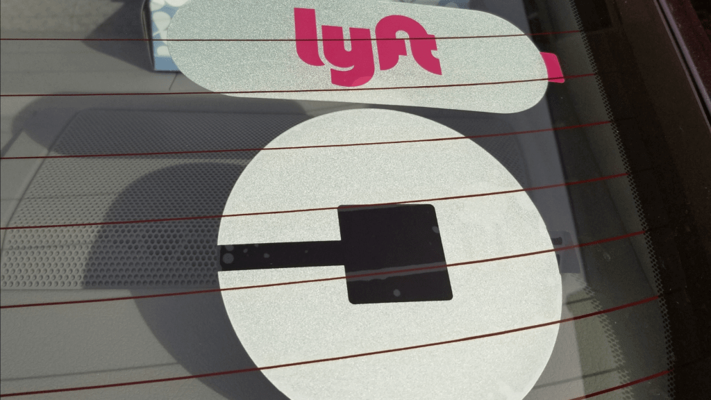 Image of a Lyft and Uber driver's windshield for a blog post on gig workers and workers' compensation.